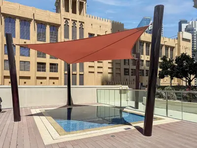 a red umbrella sitting on top of a pool at Modern Downtown 2 Bed plus Maids with Full Burj View in Dubai