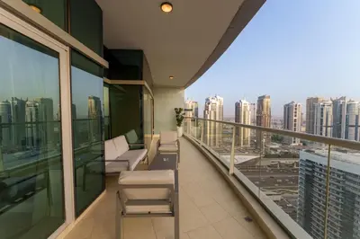 a balcony with chairs and a view of the city at Exquisite 2-Bedroom with Panoramic Marina view in Dubai