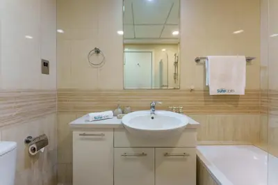 a bathroom with a sink and a mirror and a tub at Exquisite 2-Bedroom with Panoramic Marina view in Dubai