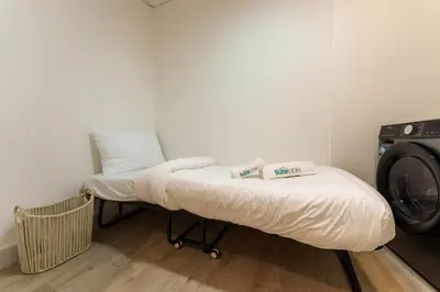 a laundry room with a bed and a washing machine at Exquisite 2-Bedroom with Panoramic Marina view in Dubai
