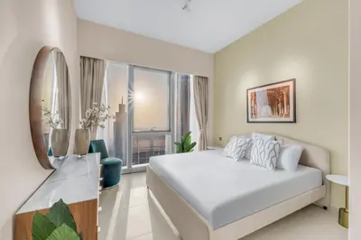a white bedroom with a bed and a large window at Skyline View, Stay High Rise Luxury next to Burj in Dubai