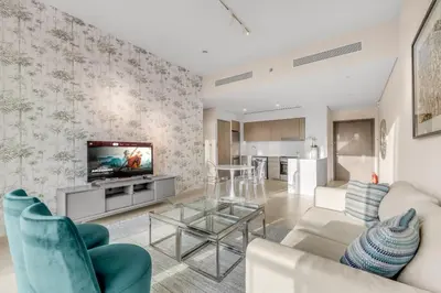 a living room with a couch and a tv at Skyline View, Stay High Rise Luxury next to Burj in Dubai