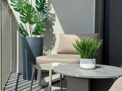 a living room with a couch and a table with plants at Welhome - Chic Studio with Balcony & City Views in Dubai in Dubai