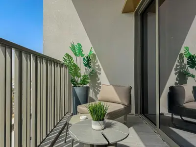 a balcony with two chairs and a table and plants at Welhome - Chic Studio with Balcony & City Views in Dubai in Dubai