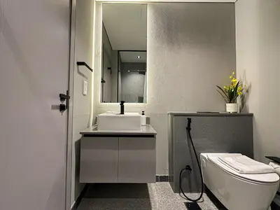 a bathroom with a sink and a toilet and a mirror at Welhome - Chic Studio with Balcony & City Views in Dubai in Dubai
