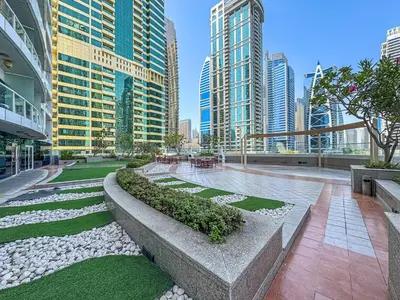 a park in the middle of a city with tall buildings at Comfy Studio with Views Near Marina & Burj Al in Dubai