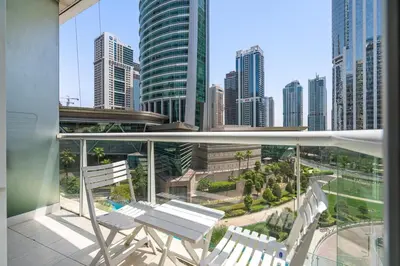 a balcony with two chairs and a view of a city at Comfy Studio with Views Near Marina & Burj Al in Dubai