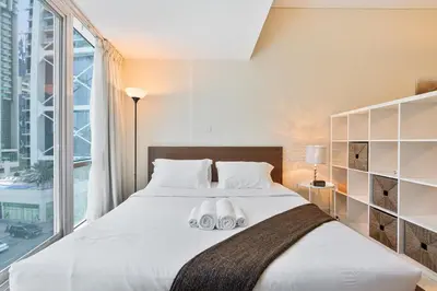 a bedroom with a large bed with two towels on it at Comfy Studio with Views Near Marina & Burj Al in Dubai