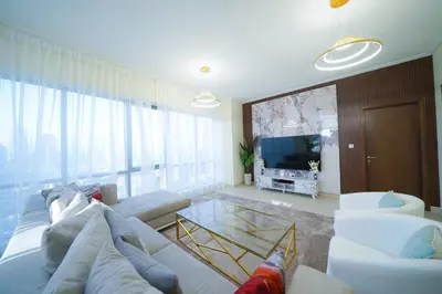 a living room with a white couch and a tv at Stunning 4BR Apartment with Full Burj Khalifa and Fountain View in Dubai