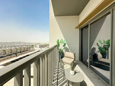 a balcony with a chair and a view of a city at Welhome - Elegant Studio with Skyline Views & Comfort in Dubai