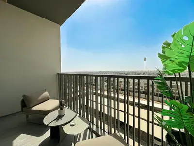 a room with a balcony with a chair and a table at Welhome - Elegant Studio with Skyline Views & Comfort in Dubai
