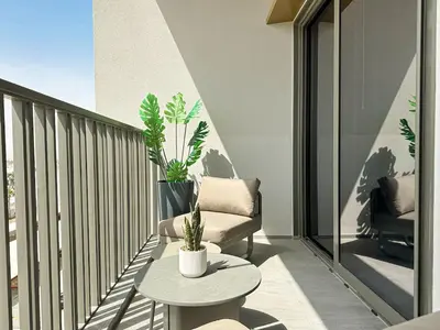 a balcony with a couch and a table on a balcony at Welhome - Elegant Studio with Skyline Views & Comfort in Dubai