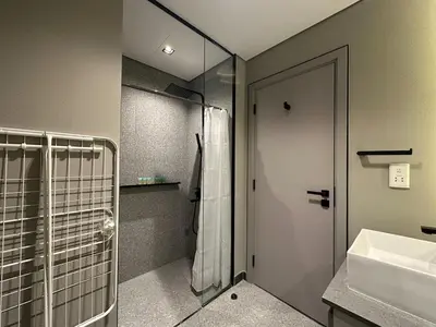 a bathroom with a shower and a sink at Welhome - Elegant Studio with Skyline Views & Comfort in Dubai