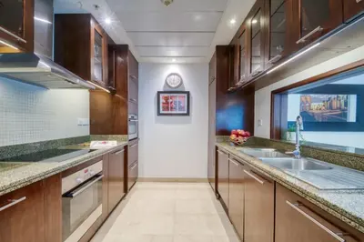 a kitchen with wooden cabinets and a sink at The Smart Concierge - Delphine in Dubai