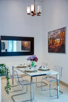 a dining room with a glass table and chairs at The Smart Concierge - Delphine in Dubai