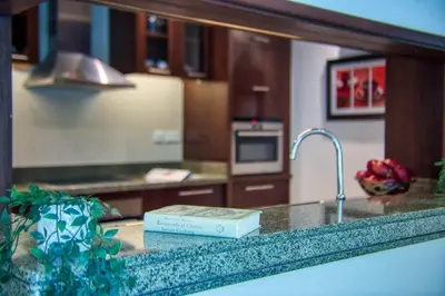 a kitchen with a sink and a book on a counter at The Smart Concierge - Delphine in Dubai