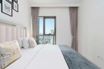 a bedroom with a white bed with a large window at Creek Side 18 I Harbor Views I in Dubai