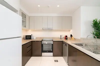 a kitchen with white cabinets and a stove top oven at Creek Side 18 I Harbor Views I in Dubai
