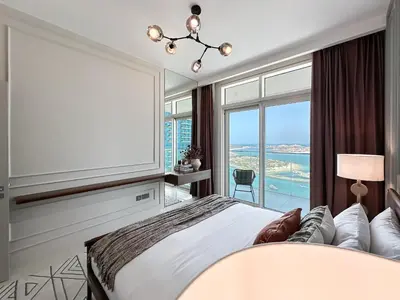 a bedroom with a large white bed and a large window at Trophy-Sunset Coral Retreat Beachfront Living in Dubai