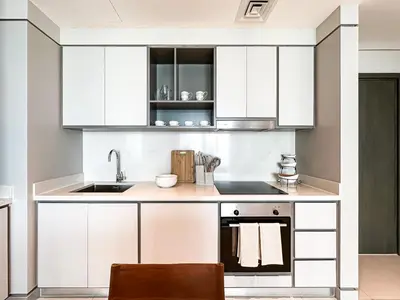 a kitchen with white cabinets and a sink at Trophy-Sunset Coral Retreat Beachfront Living in Dubai