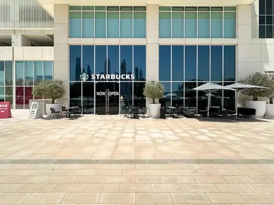 a starbucks sign in front of a building at Trophy-Sunset Coral Retreat Beachfront Living in Dubai