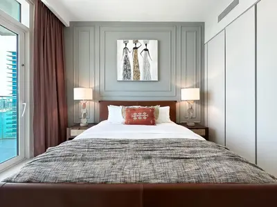 a bedroom with a large bed with two lamps at Trophy-Sunset Coral Retreat Beachfront Living in Dubai