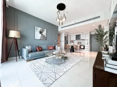 a living room with a blue couch and a table at Trophy-Sunset Coral Retreat Beachfront Living in Dubai