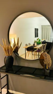 a living room with a table and a mirror at Downtown Apt - Near Burj Khalifa - Free Parking in Dubai