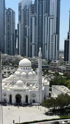 a large white building in front of a city at Downtown Apt - Near Burj Khalifa - Free Parking in Dubai