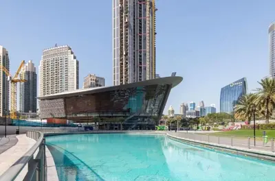 a large swimming pool in a city with tall buildings at Downtown Apt - Near Burj Khalifa - Free Parking in Dubai