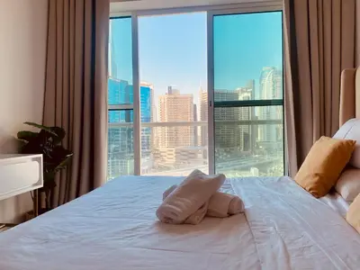 a bed with a stuffed animal on it in front of a window at Canal View Comfort Business Bay in Dubai