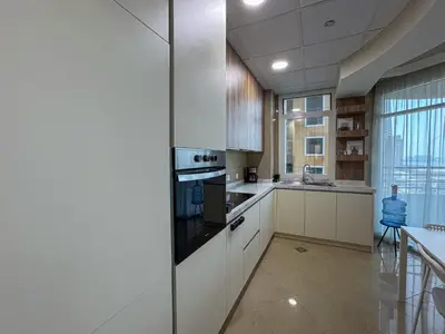 a kitchen with white cabinets and a stove at DreamShoma-Sea View 2BR Pool Gym in Dubai