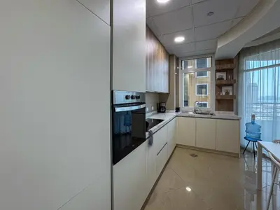 a kitchen with white cabinets and a stove at DreamShoma-Sea View 2BR Pool Gym in Dubai