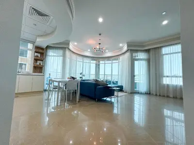 a living room with a blue couch and a table at DreamShoma-Sea View 2BR Pool Gym in Dubai