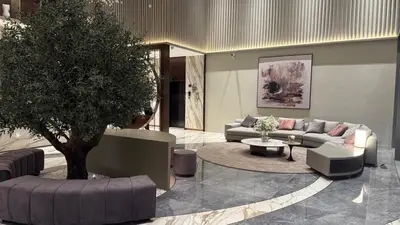 a living room with a couch and a table and a tree at Brand new fully furnished studio in Dubai