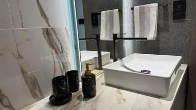 a bathroom with a white sink and a mirror at Brand new fully furnished studio in Dubai