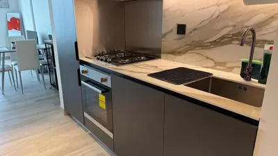 a kitchen with a sink and a stove top oven at Brand new fully furnished studio in Dubai