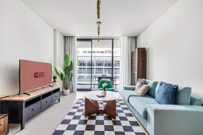a living room with a blue couch and a tv at GuestReady – Modern comfort in JVC in Dubai
