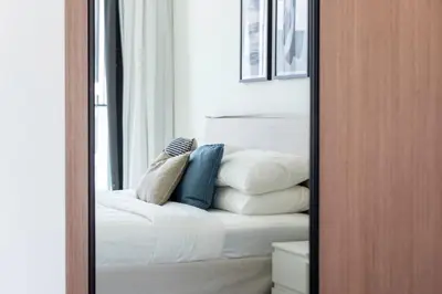 a mirror with a pile of pillows on a bed at GuestReady – Modern comfort in JVC in Dubai