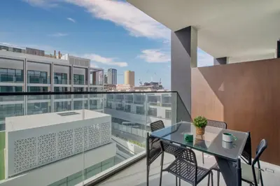 an apartment balcony with a glass table and chairs at GuestReady – Modern comfort in JVC in Dubai
