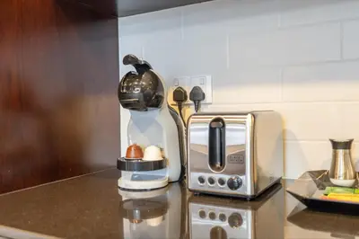 a coffee maker on a counter next to a toaster at 29 Boulevard by EMAAR 1BR 4min Walk to the Burj and Dubai Mall in Dubai