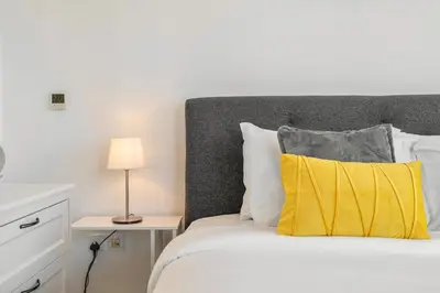 a bedroom with a bed with a yellow pillow at 29 Boulevard by EMAAR 1BR 4min Walk to the Burj and Dubai Mall in Dubai