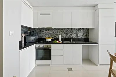 a white kitchen with a sink and a microwave at Sky High 1BR in City View with 41st Floor Views in Dubai