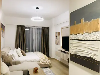 a hotel room with a bed and a couch at PANTHEON ELYSEE III Elite Apartment Spacious luxury stay with huge pool , modern gym and Complimentary welcome pack in Dubai