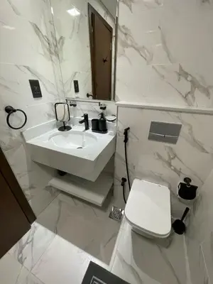 a white bathroom with a sink and a toilet at PANTHEON ELYSEE III Elite Apartment Spacious luxury stay with huge pool , modern gym and Complimentary welcome pack in Dubai