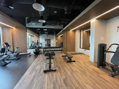 a gym with treadmills and chairs in a room at PANTHEON ELYSEE III Elite Apartment Spacious luxury stay with huge pool , modern gym and Complimentary welcome pack in Dubai