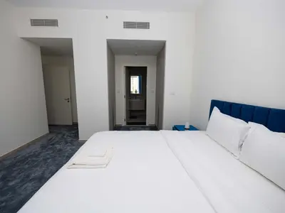 a bedroom with a large white bed with a blue headboard at Beach Access, Burj Khalifa View, Family Friendly in Dubai
