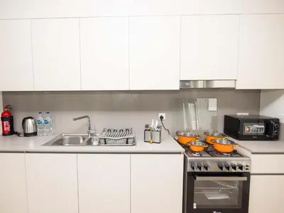 a kitchen with white cabinets and a stove top oven at Beach Access, Burj Khalifa View, Family Friendly in Dubai