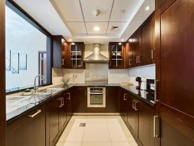 a kitchen with wooden cabinets and a large window at Golden Homes 29 blvd tower Urban nest 1BR Near Dubai mall & burj khalifa downtown dubai in Dubai