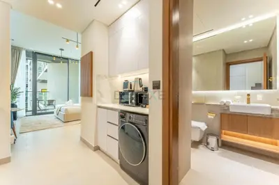 a kitchen with a washer and dryer in a bathroom at Studio Near Dubai Autodrome & Trump Golf Club, Binghatti Amber, JVC By Deluxe Holiday Homes in Dubai